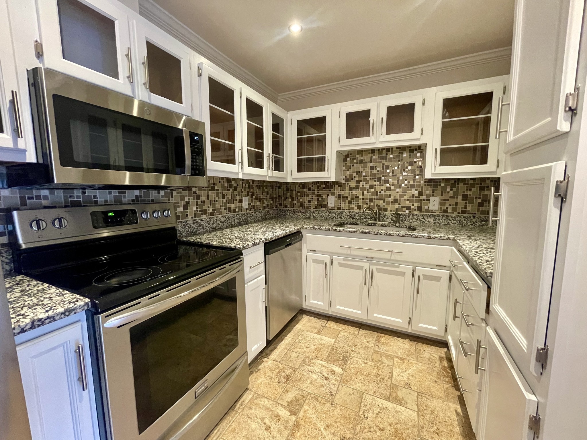 a kitchen with stainless steel appliances granite countertop a stove microwave and sink