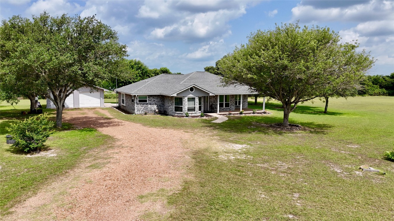 a view of a house with a yard and tree s