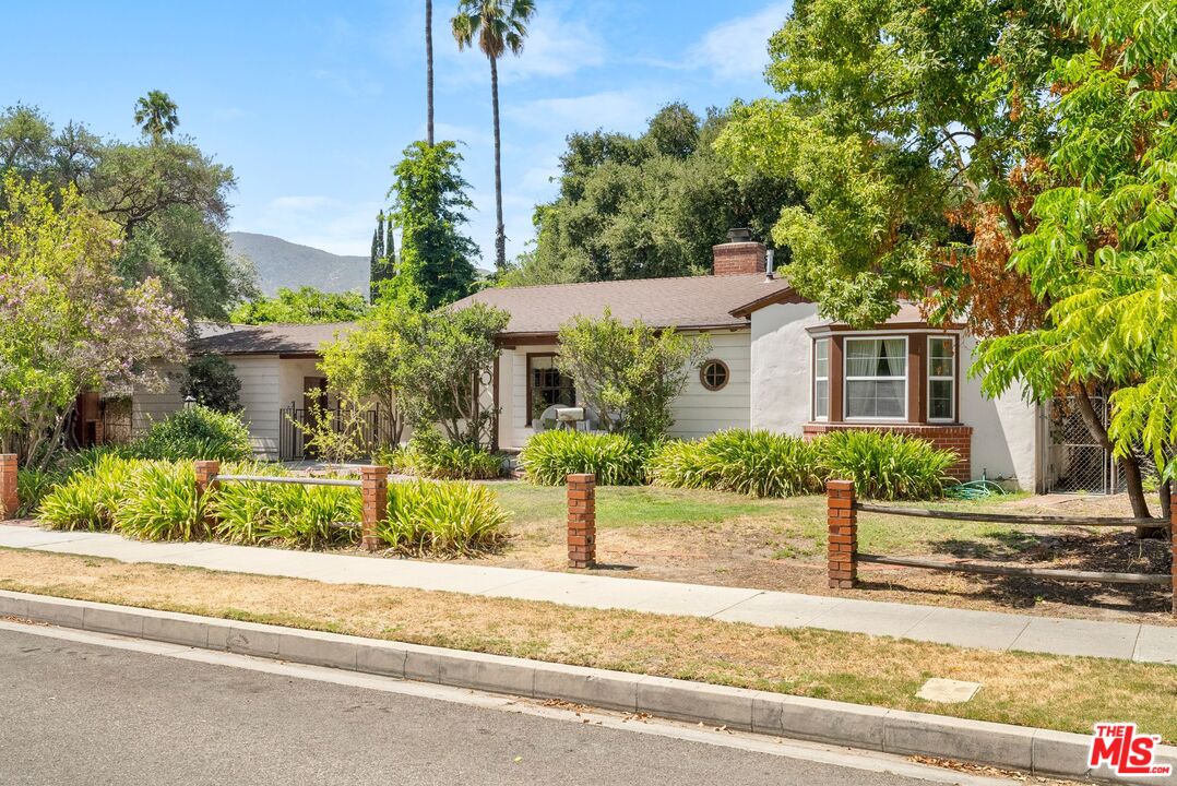 a front view of a house with a yard and potted plants