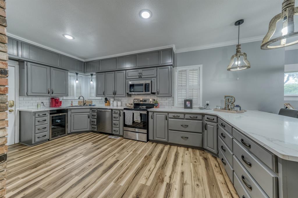 a kitchen with granite countertop a sink cabinets and stainless steel appliances