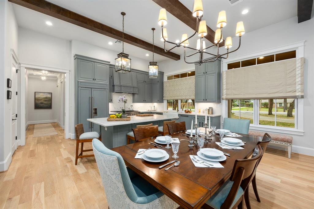 a dining room with stainless steel appliances granite countertop a rug a dining table and chairs with wooden floor