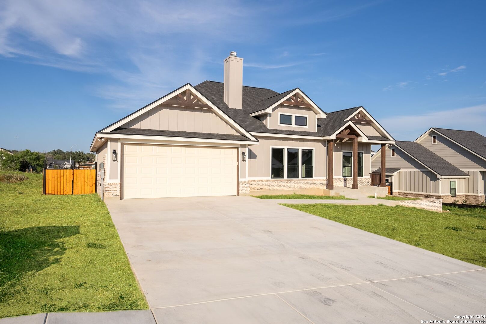 a view of a big house with a big yard and large trees