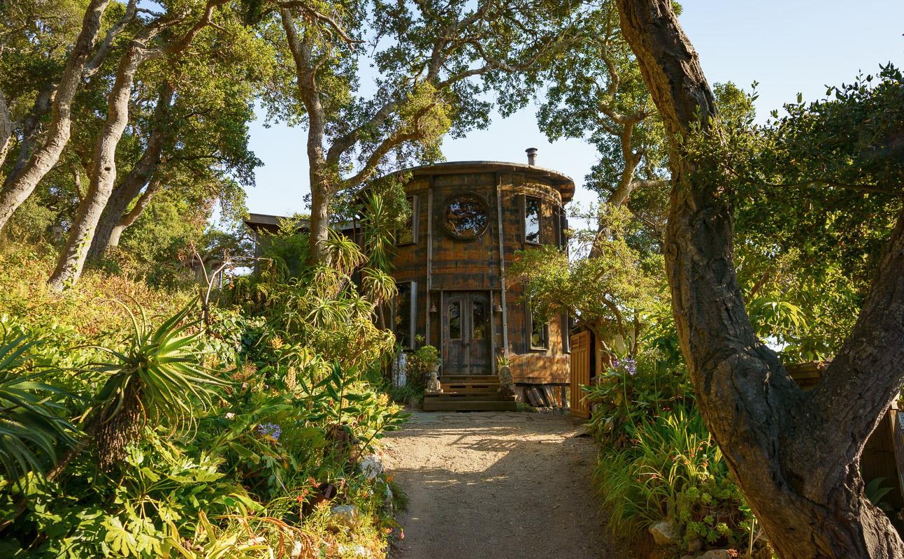 a front view of a house with a tree