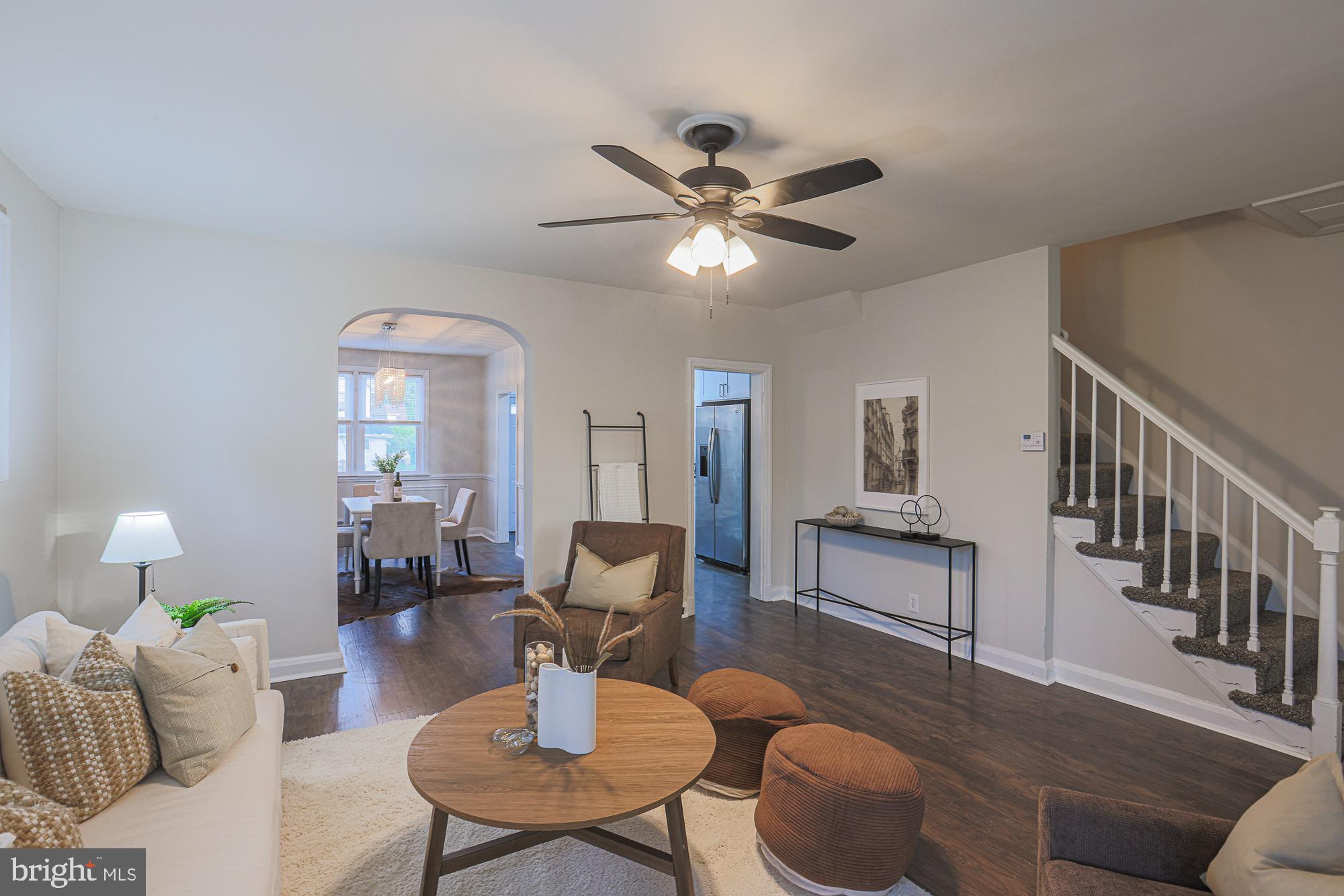 a living room with furniture a chandelier and a dining table