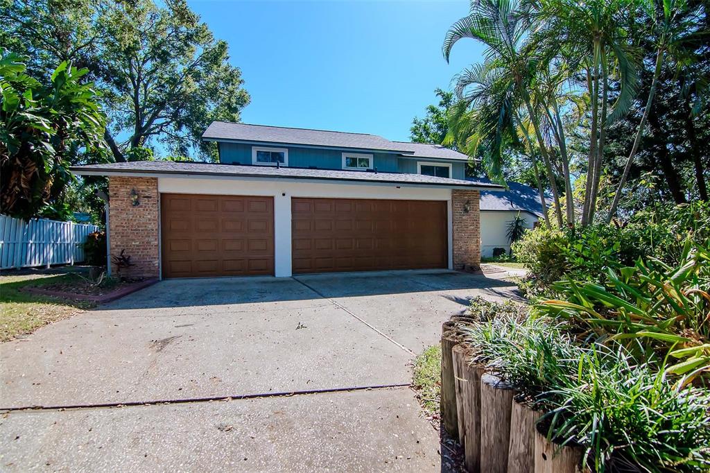 Front of Cul-de-sac Property showing Large Driveway, 3-Car Garage with Newer Garage Doors (2017) and Walkway to Entrance and Lush Mature Landscaping