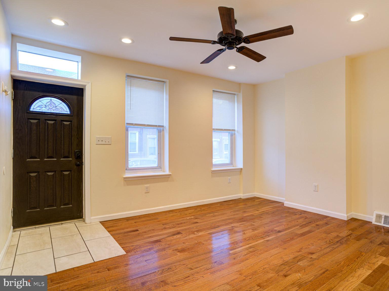 a view of a livingroom with a ceiling fan and wooden floor