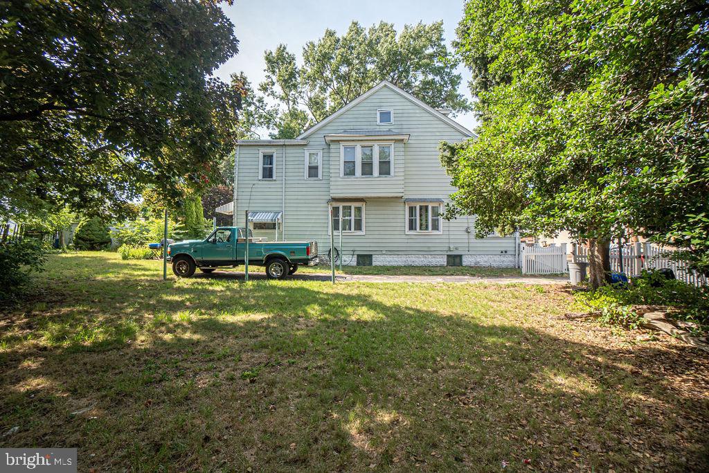 a front view of a house with a yard and trees