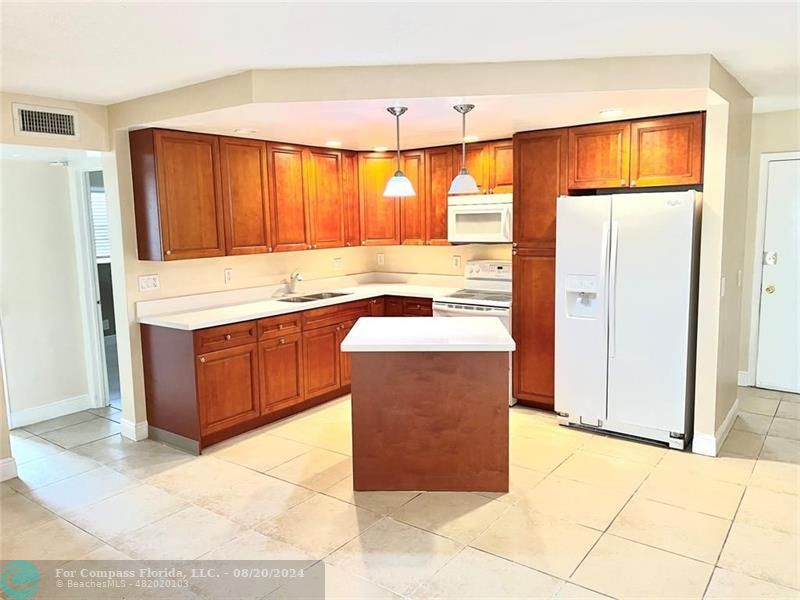 a kitchen with stainless steel appliances granite countertop a stove a refrigerator and a cabinets