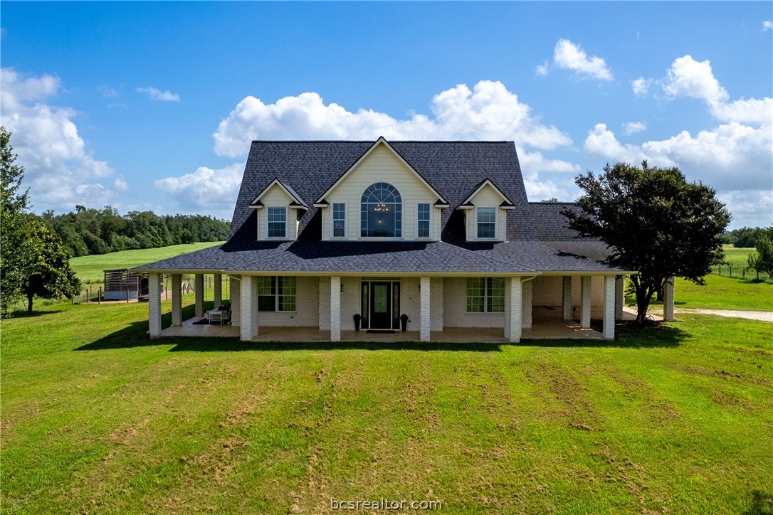 a front view of a house with a yard and trees