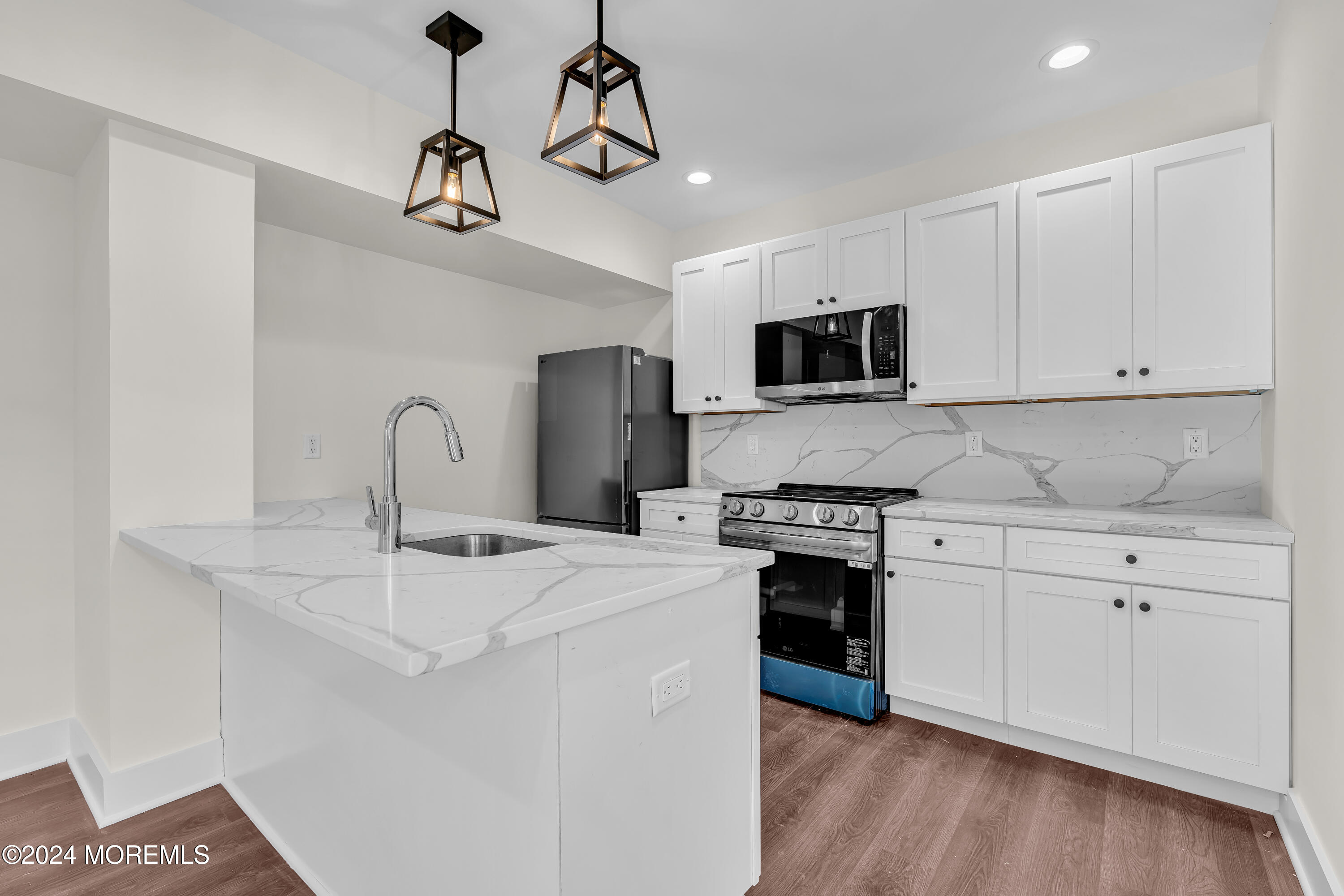 a kitchen with stainless steel appliances a stove a sink and white cabinets