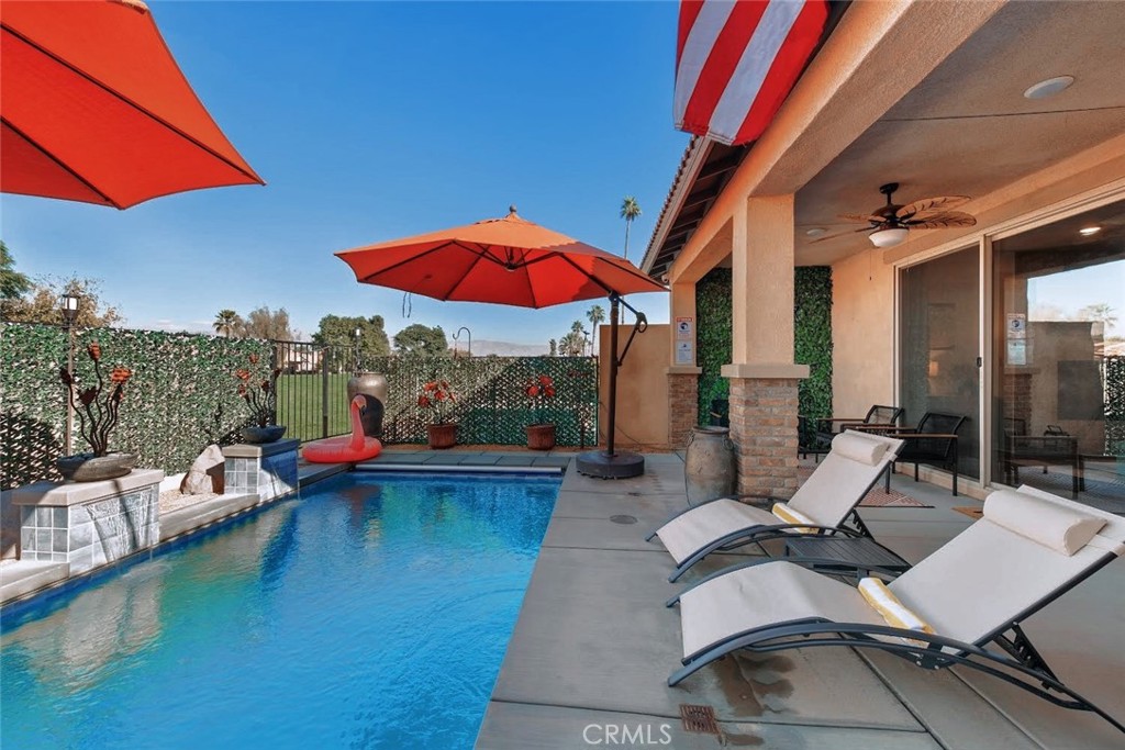 a view of a patio with chairs and table under an umbrella