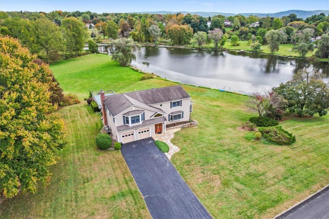 an aerial view of a house with pool and a yard