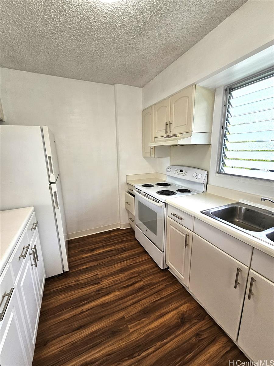 a kitchen with a sink a stove and cabinets