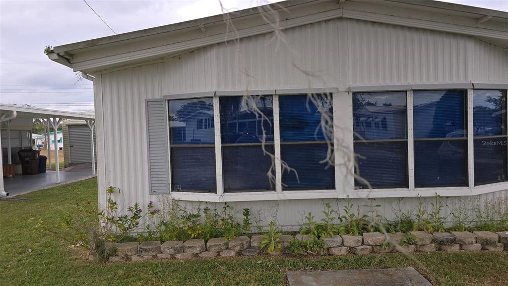 a view of a house with potted plants and large windows