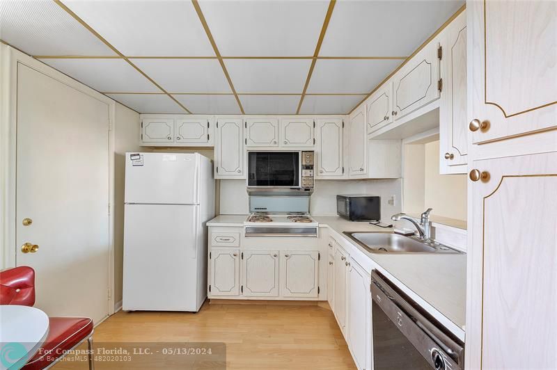 a kitchen with a sink a refrigerator a microwave and cabinets