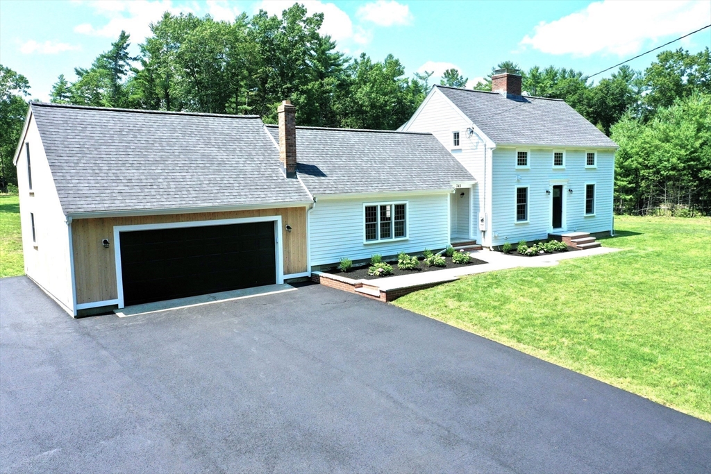 a front view of a house with yard and parking