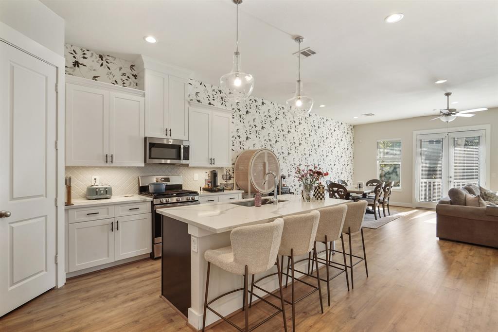 Light and bright kitchen with quartz countertops and gorgeous wallpaper that flows into the dining and living rooms.