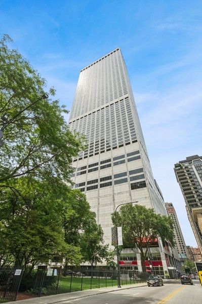 a view of a tall building next to a yard