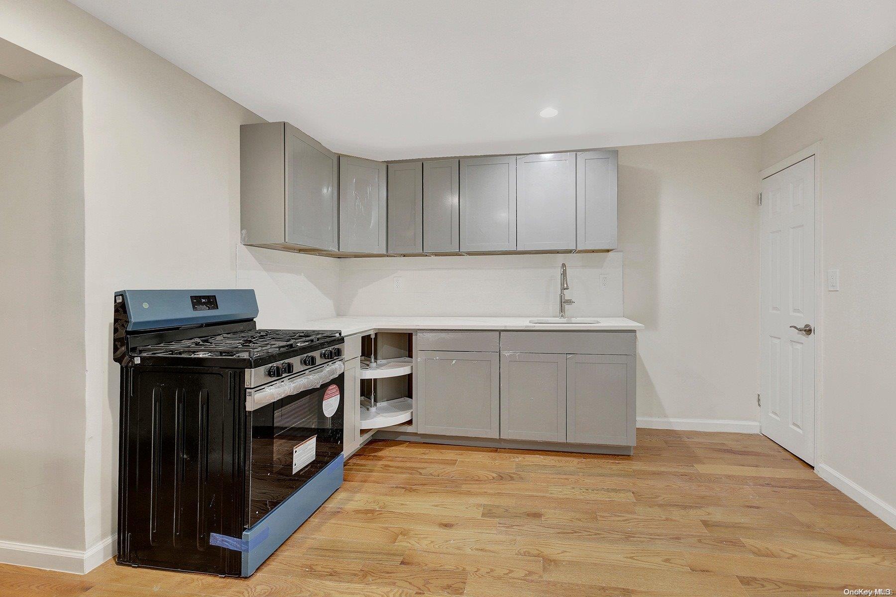 a kitchen with sink stove and cabinets