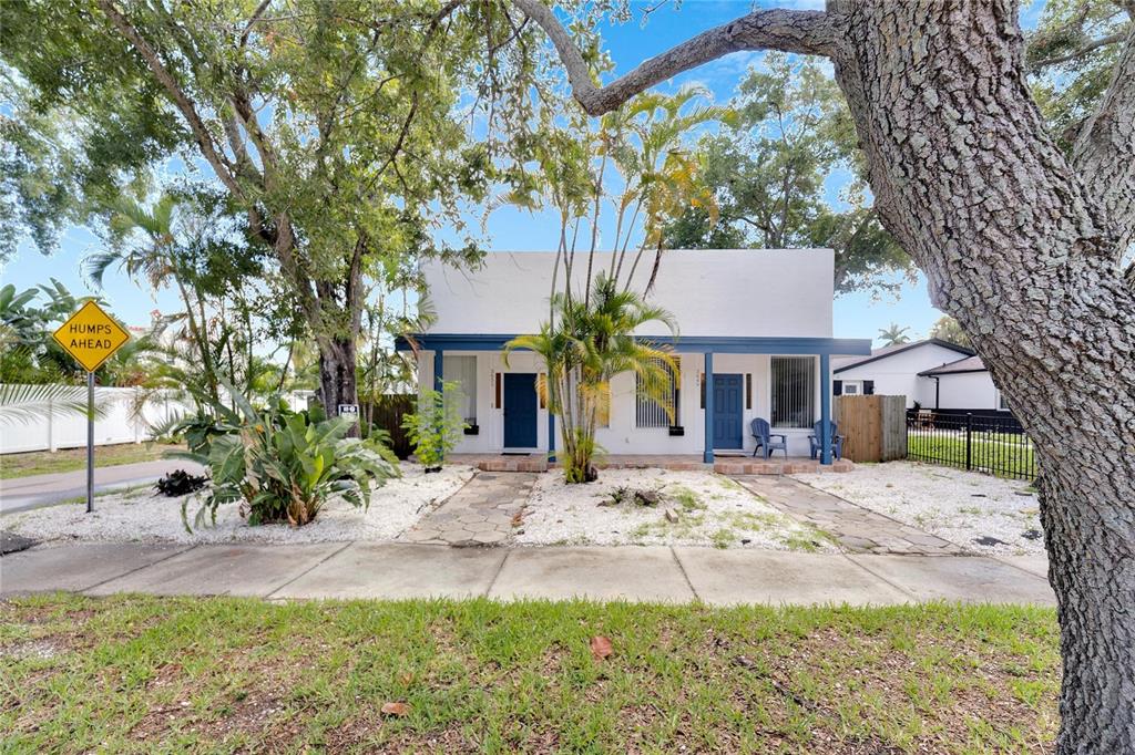 a view of a house with a tree in front of it