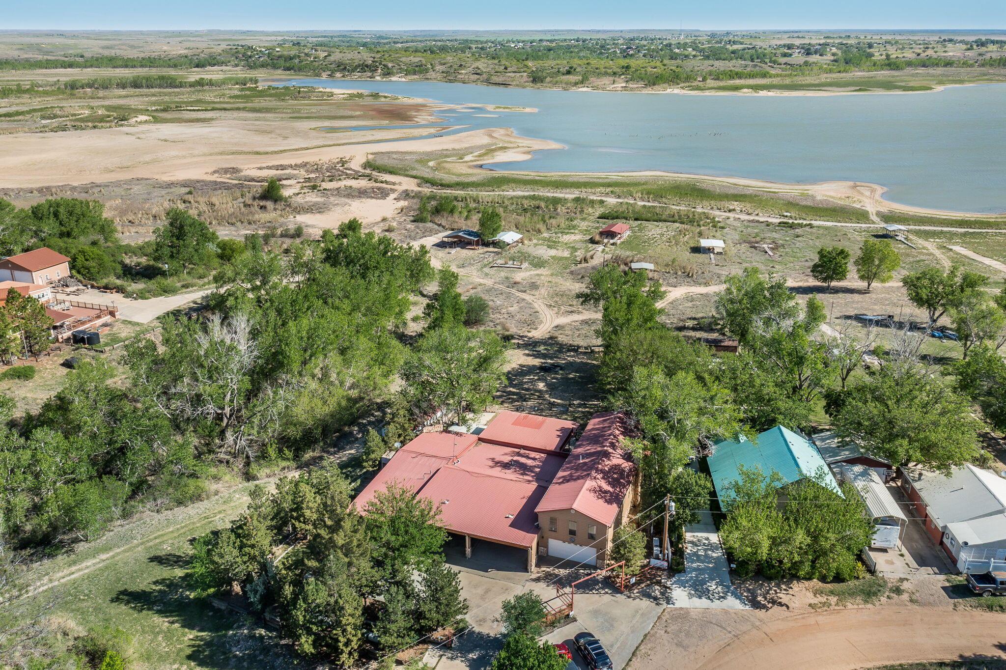 an aerial view of ocean and residential houses with outdoor space