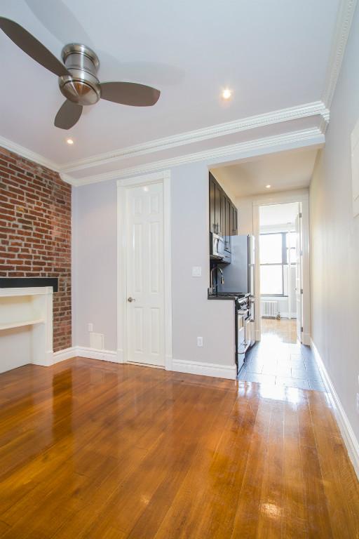 a view of a livingroom with wooden floor and a ceiling fan