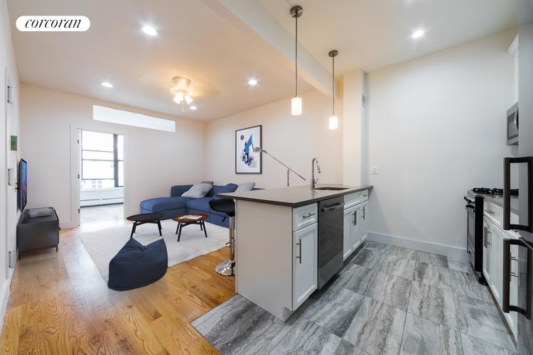 a kitchen with a sink cabinets and wooden floor