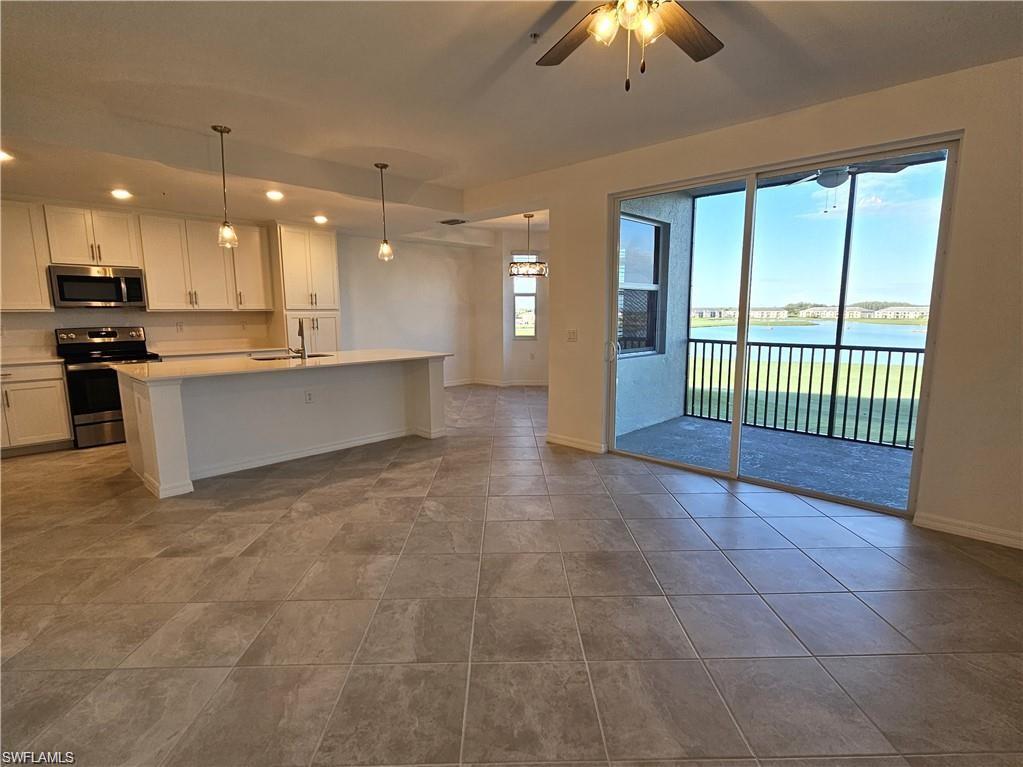 Kitchen featuring a healthy amount of sunlight, white cabinetry, a water view, and stainless steel appliances