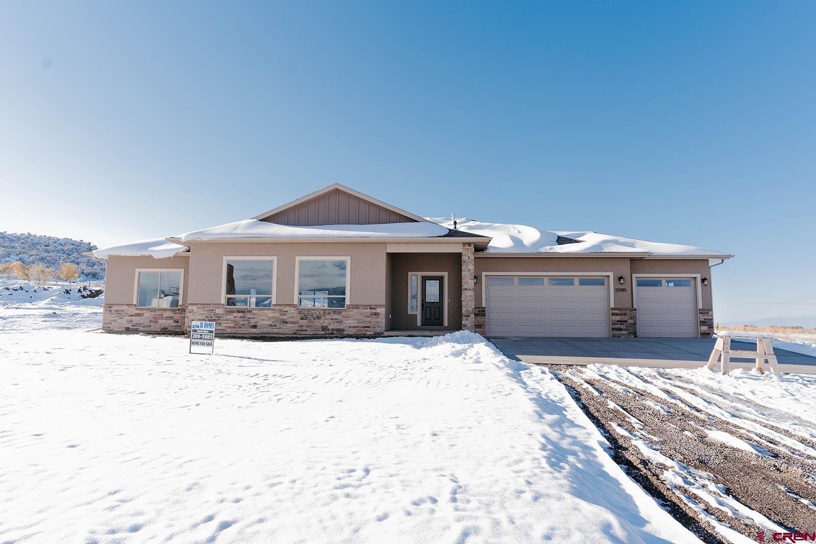 a front view of a house with a yard covered with snow