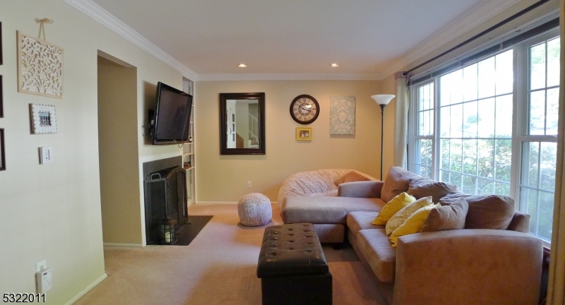 a living room with furniture a large window and a flat screen tv