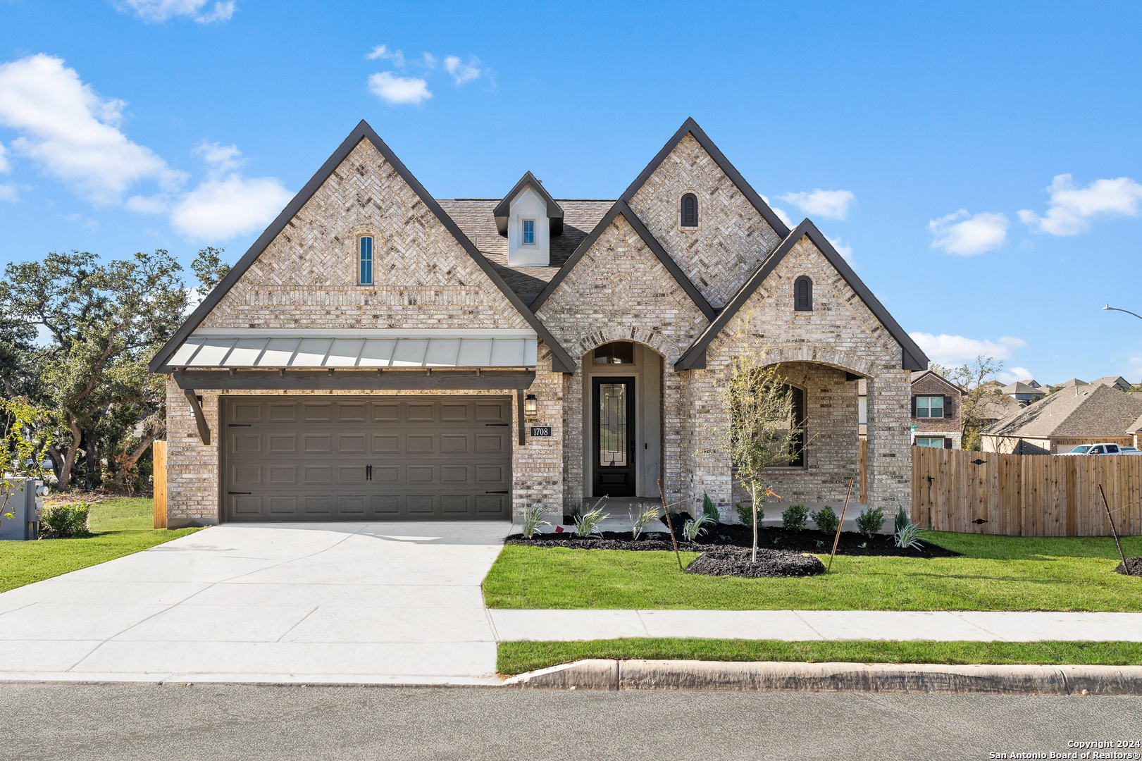 a front view of a house with a garden and garage