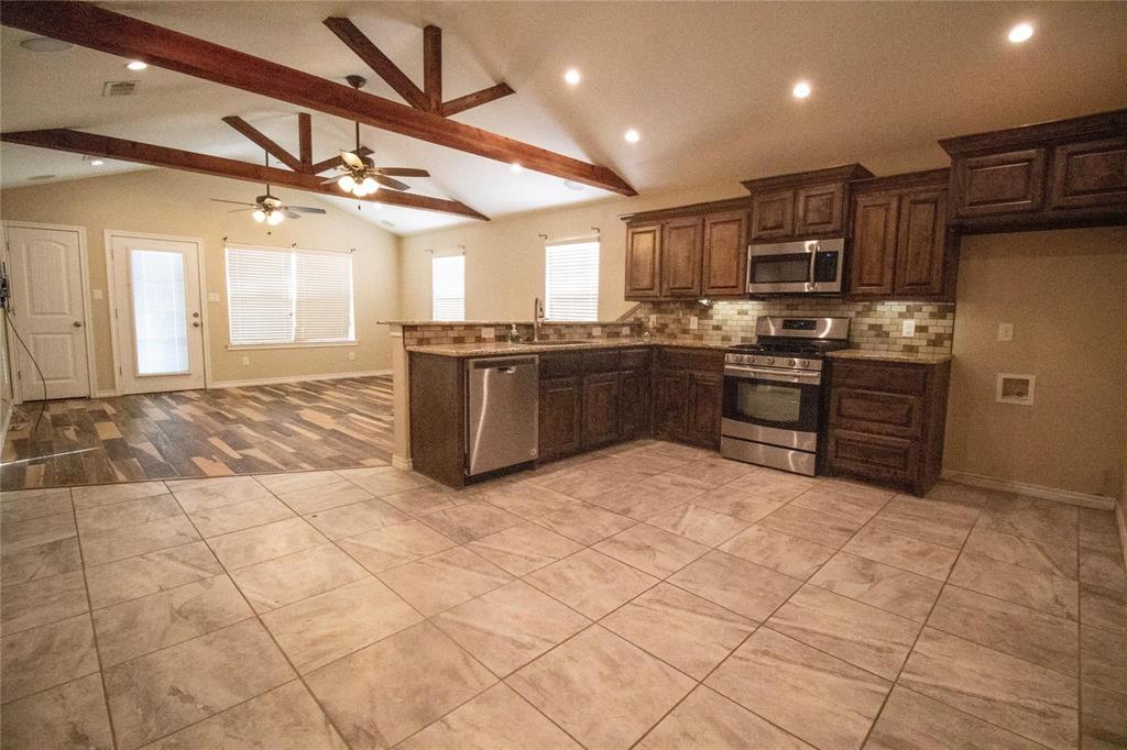 a large kitchen with stainless steel appliances granite countertop a stove a sink dishwasher and a refrigerator