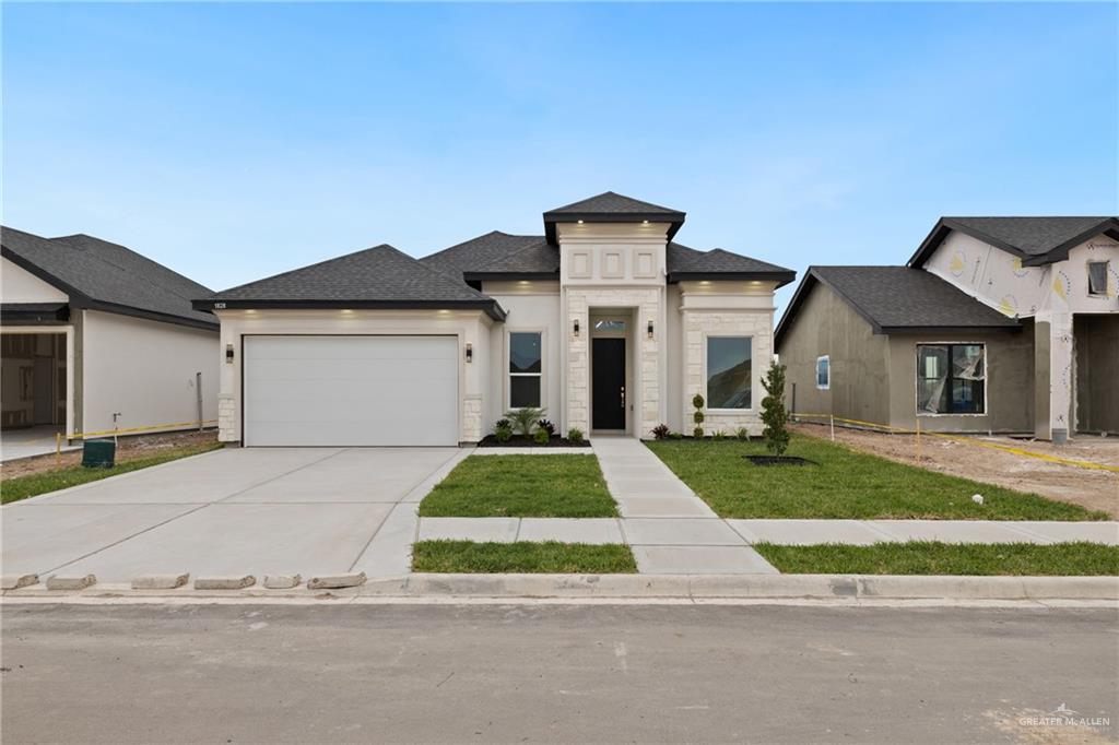 a front view of a house with a yard and garage