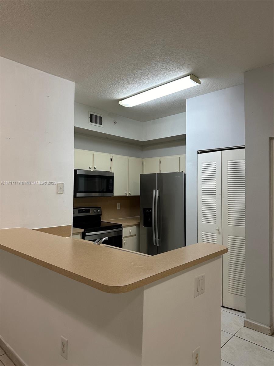 a kitchen with stainless steel appliances a refrigerator and a stove top oven