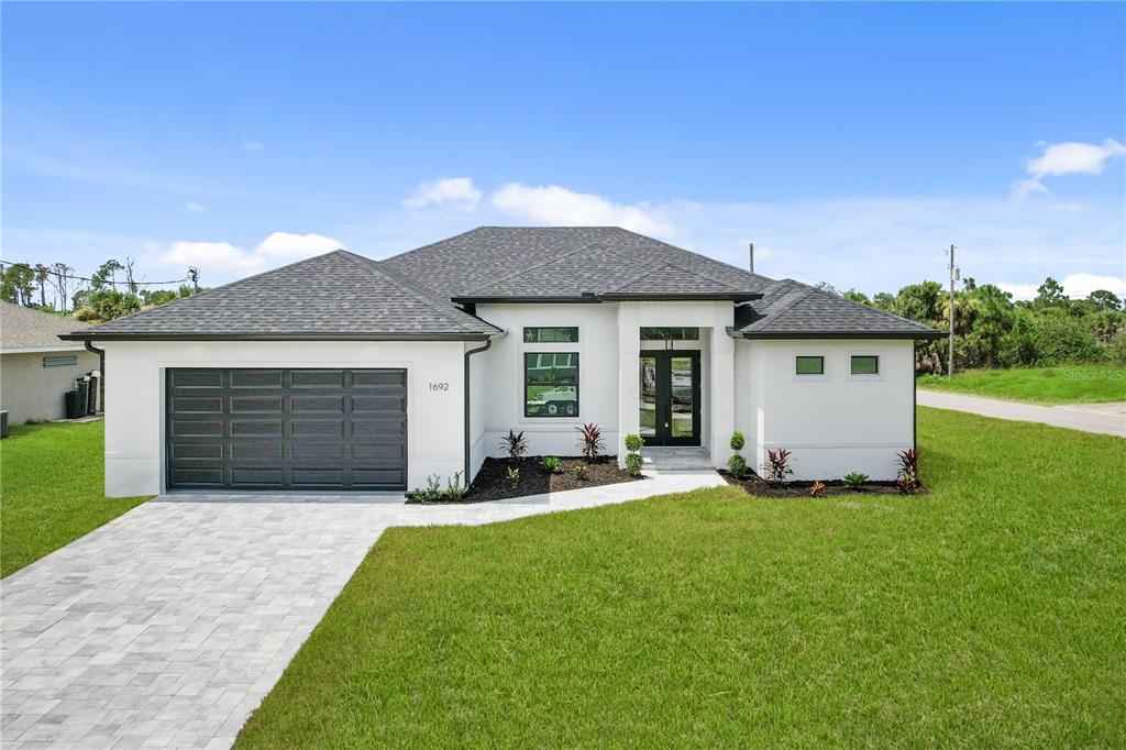 a front view of a house with a yard and garage