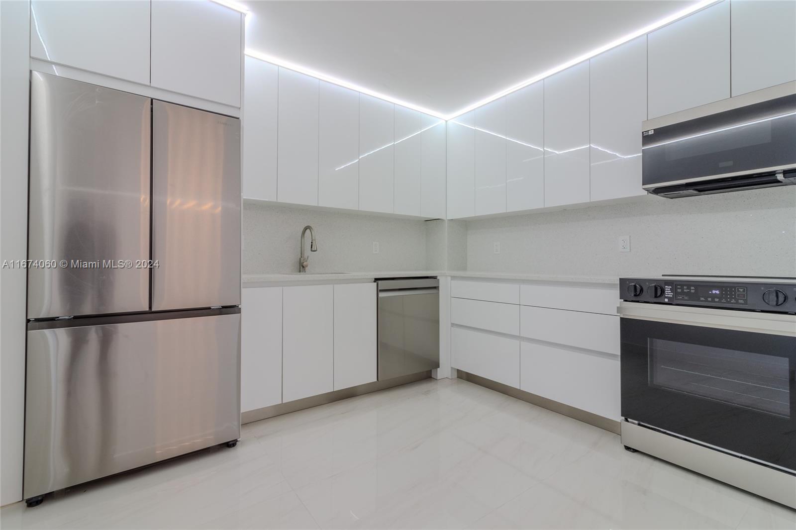 a kitchen with white cabinets and refrigerator