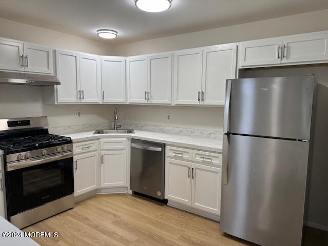 a kitchen with a refrigerator stove and white cabinets