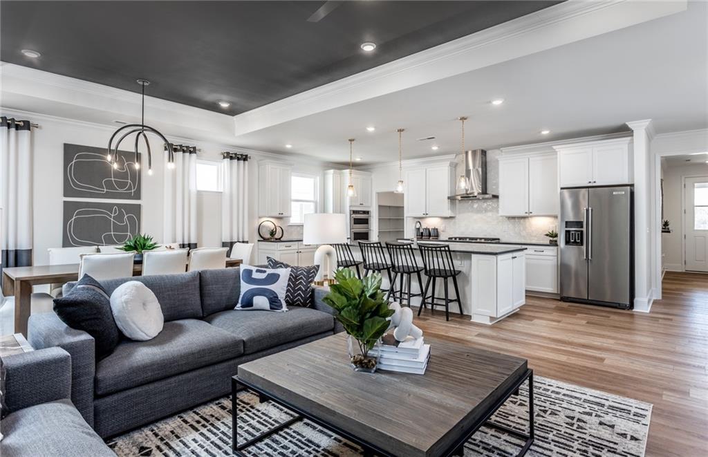 a living room kitchen with furniture and a wooden floor