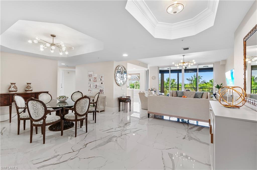 Dining room featuring a chandelier, a tray ceiling, and crown molding