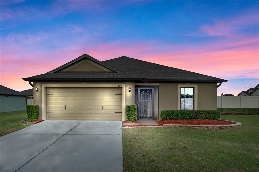 a front view of a house with a yard and garage