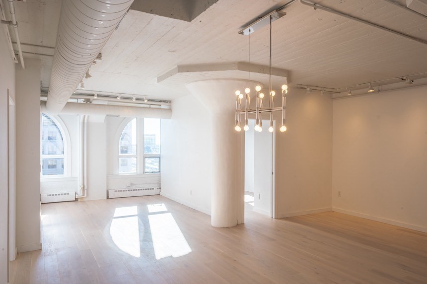 a view of a hallway with windows and chandelier