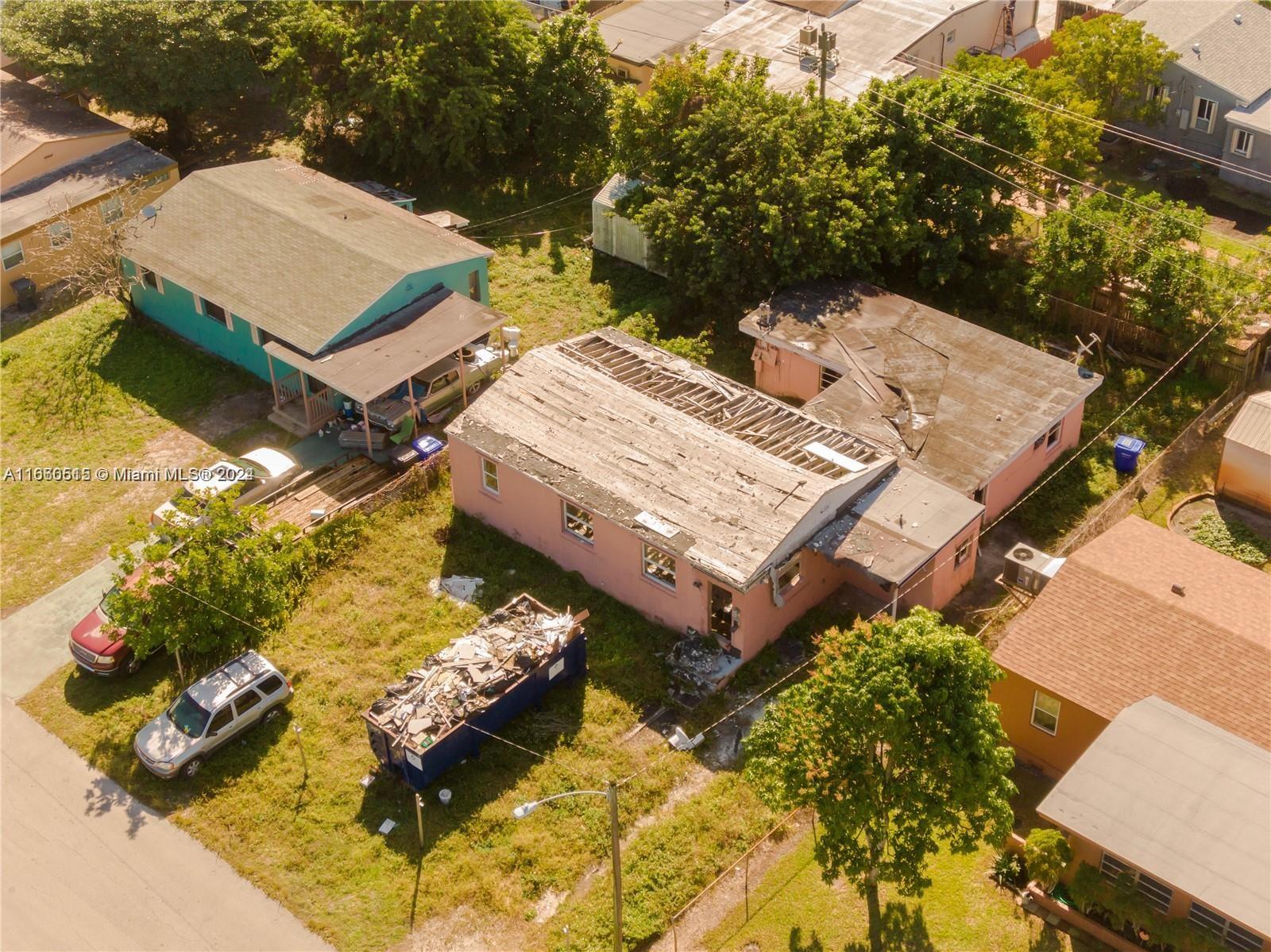 an aerial view of a house with swimming pool and large trees