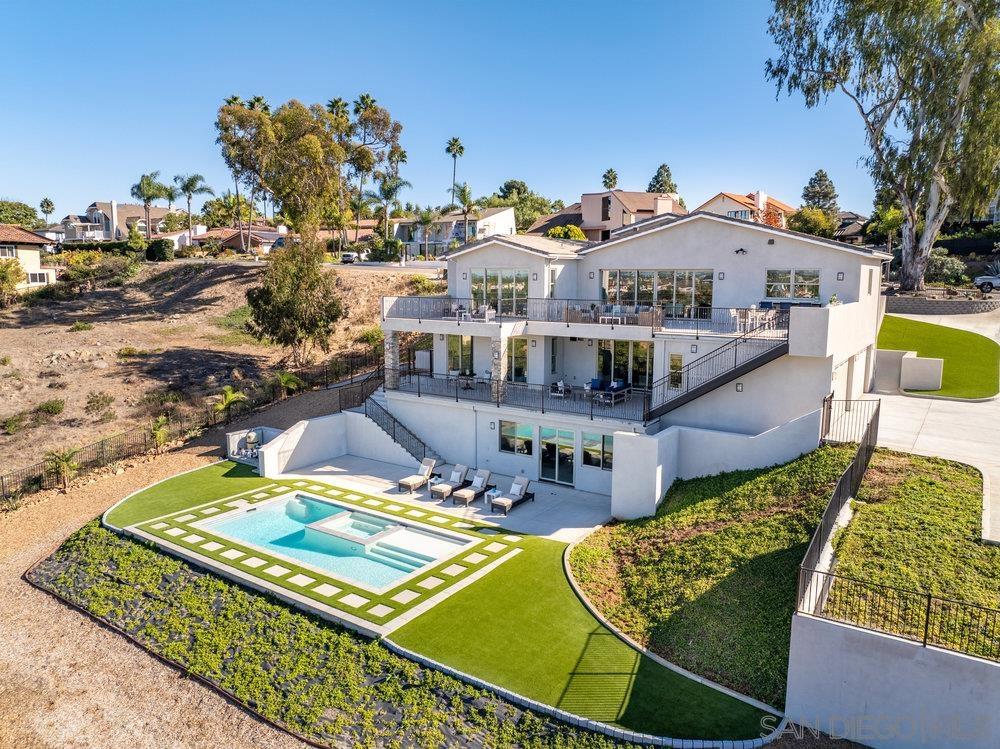 an aerial view of a house with swimming pool and furniture