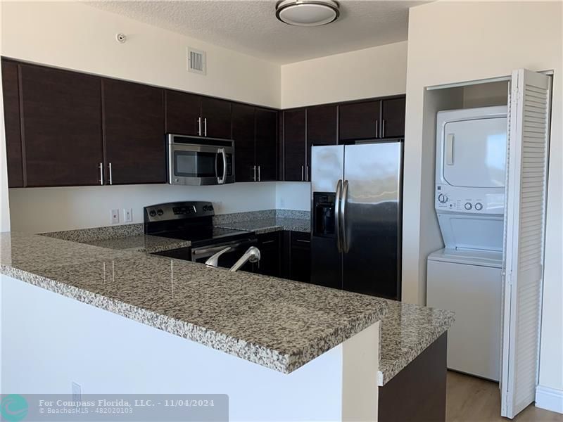 a kitchen with stainless steel appliances granite countertop a refrigerator and a sink