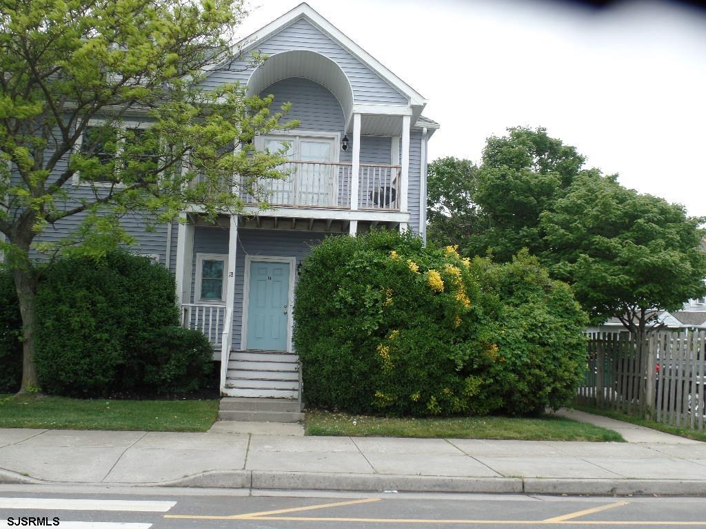 a front view of a house with garage and plants