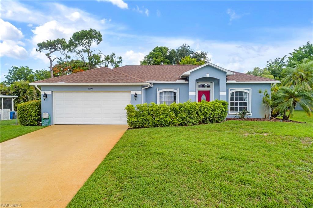 Ranch-style house featuring a front yard and a garage