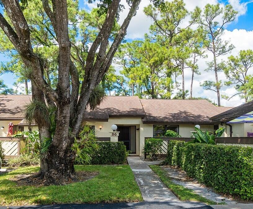 a view of house with a tree in front of it