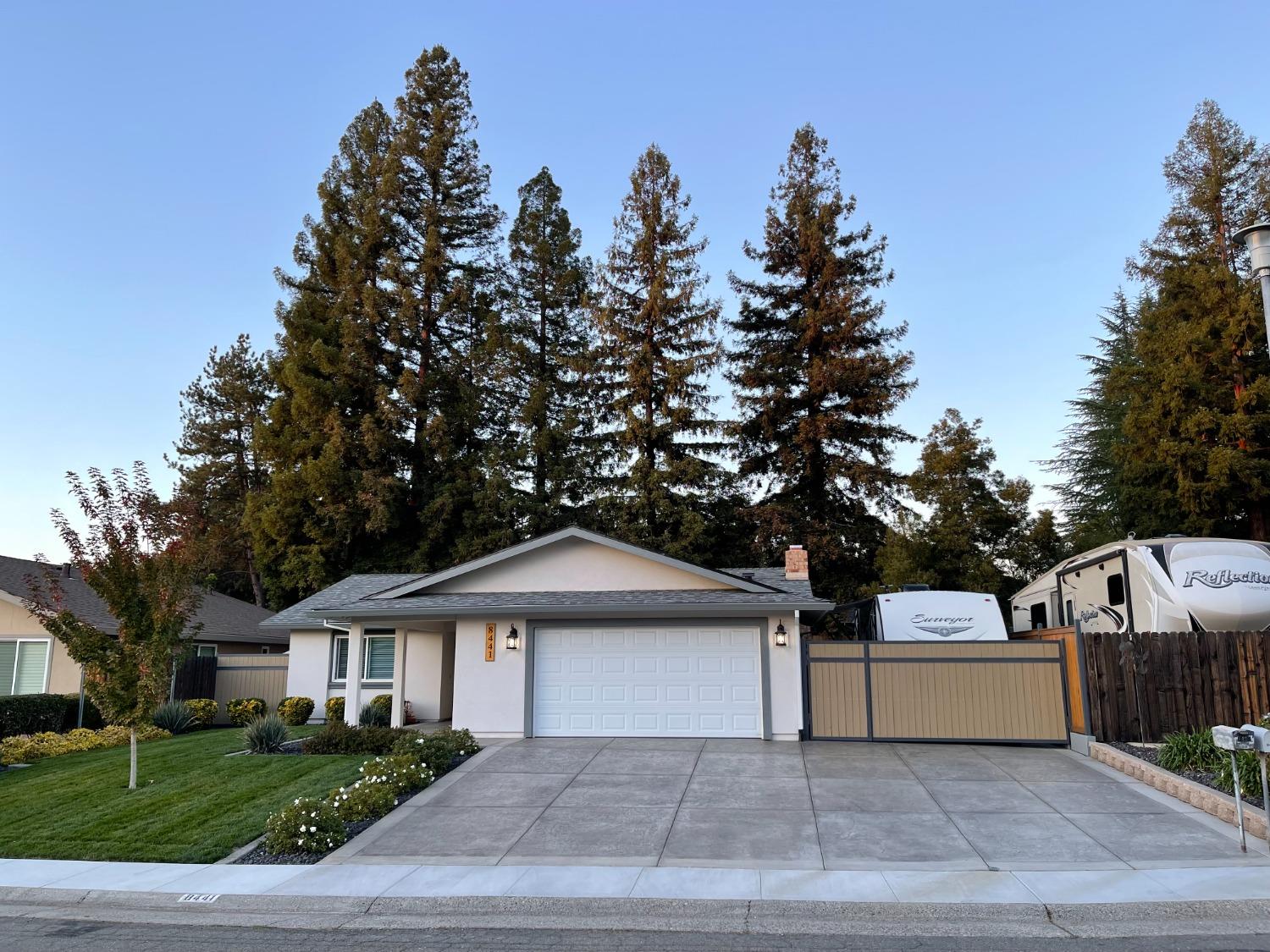 a front view of a house with a tree and a yard