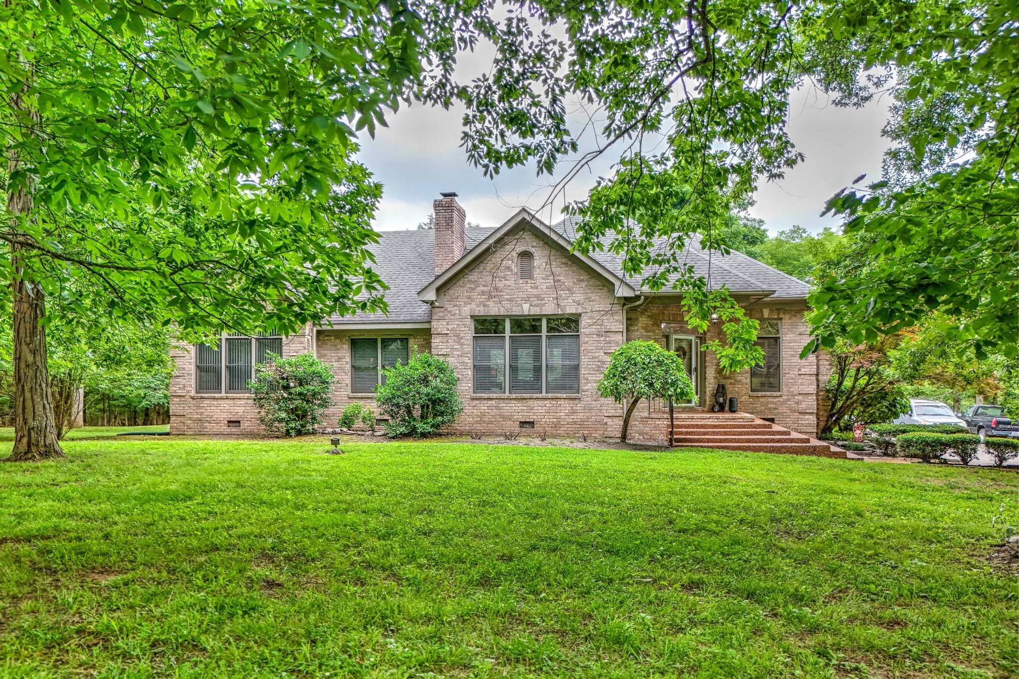 a front view of a house with a yard and green space