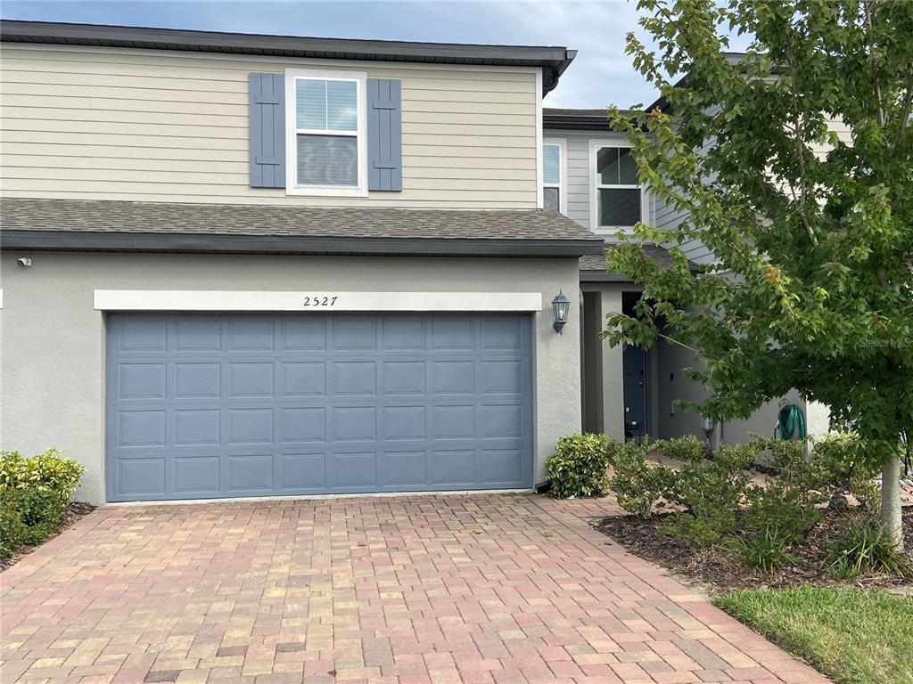 a front view of a house with a yard and garage